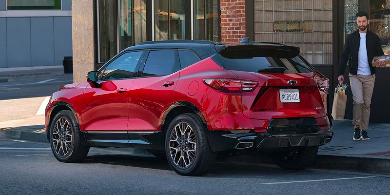 Red Chevrolet Blazer parked on city road front of building