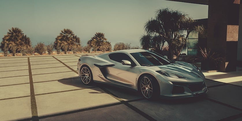 A silver Chevrolet Corvette parked in front of building Front and right view