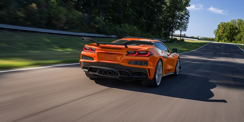 Orange carrunning on road rear view