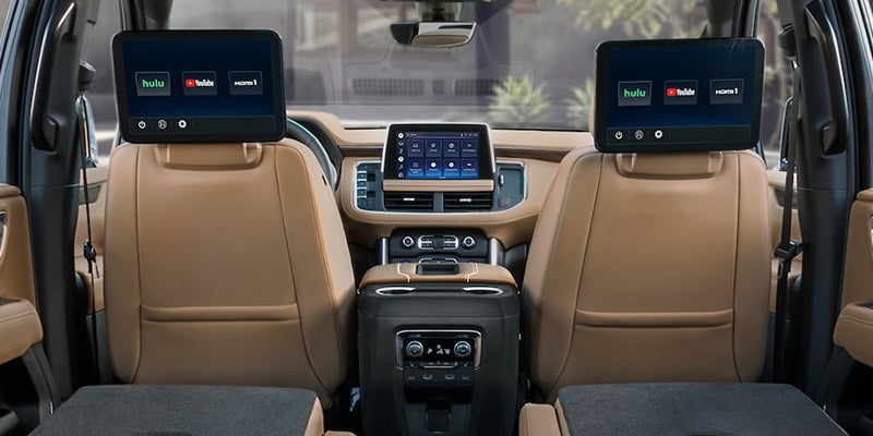 Rear-seat entertainment system in a Chevrolet Suburban with dual screens and touchscreen dashboard view