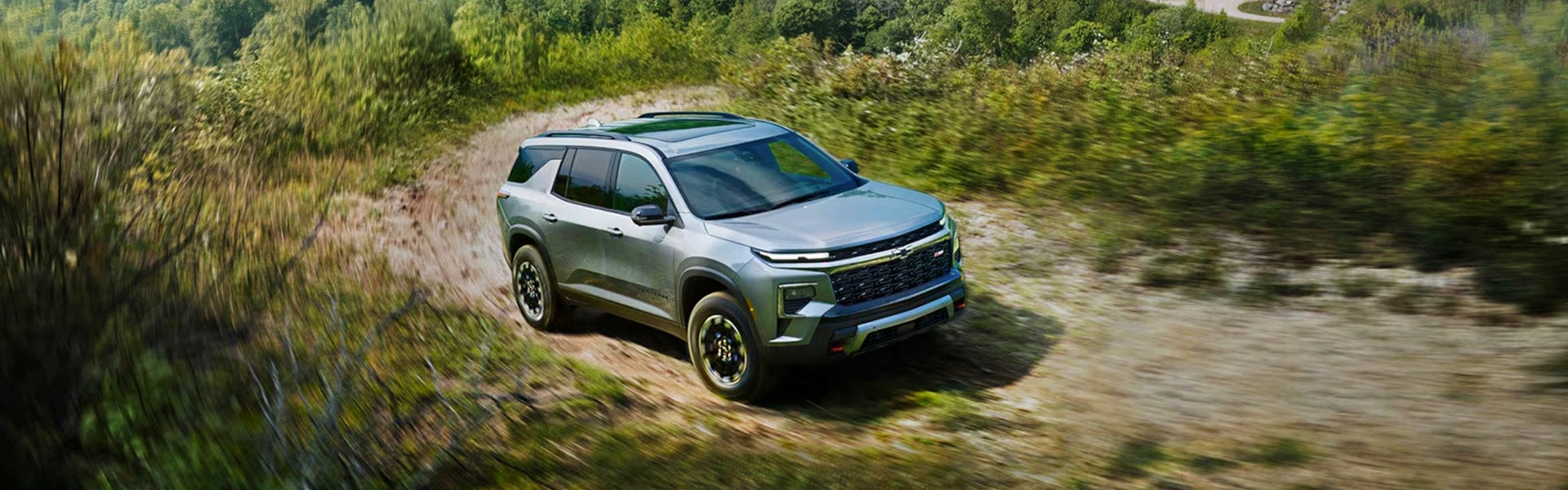 Silver Chevrolet Traverse driving in jungle