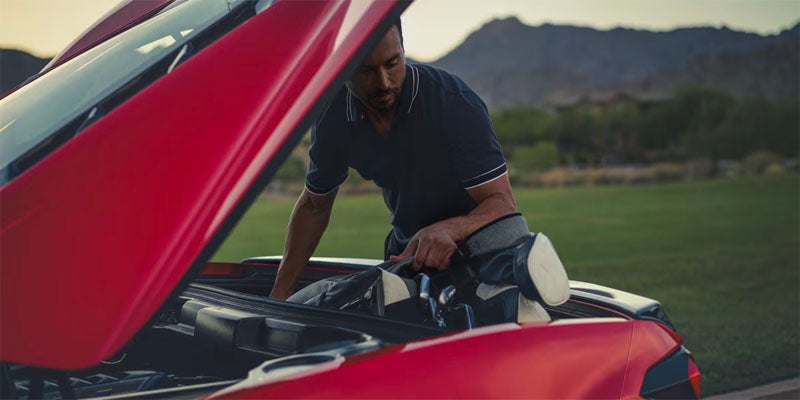 A men opens a bonnet of red Corvette Stingray