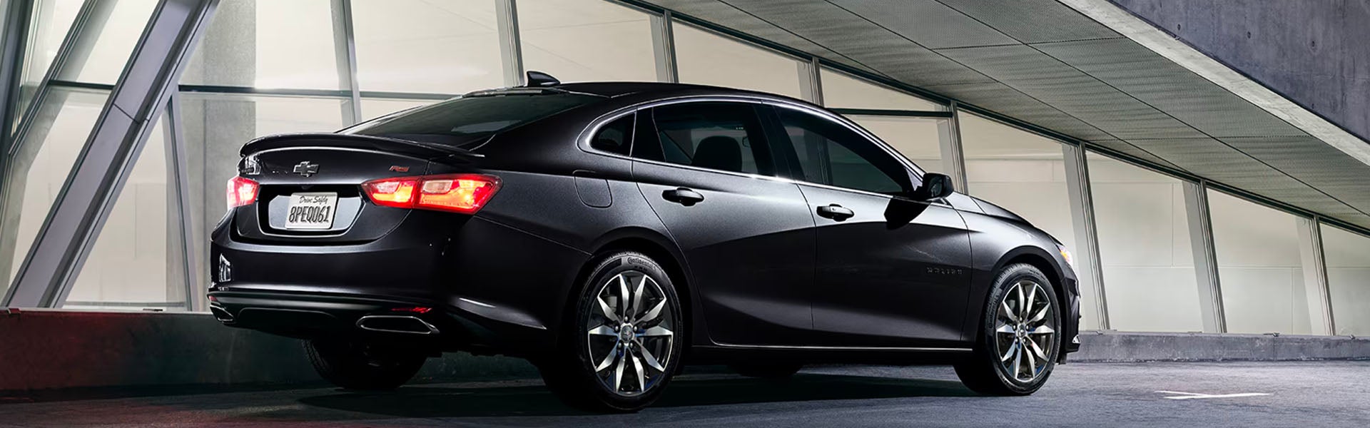 Black Chevrolet Malibu parked below the building