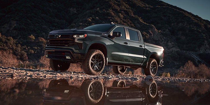 Green Chevrolet Silverado parked near river