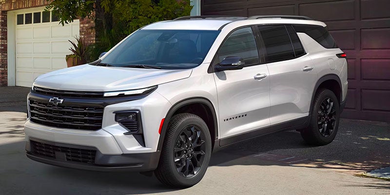 White Traverse parked front of home