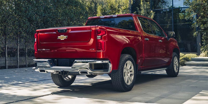 A couple is taking near Chevrolet Silverado at home parking