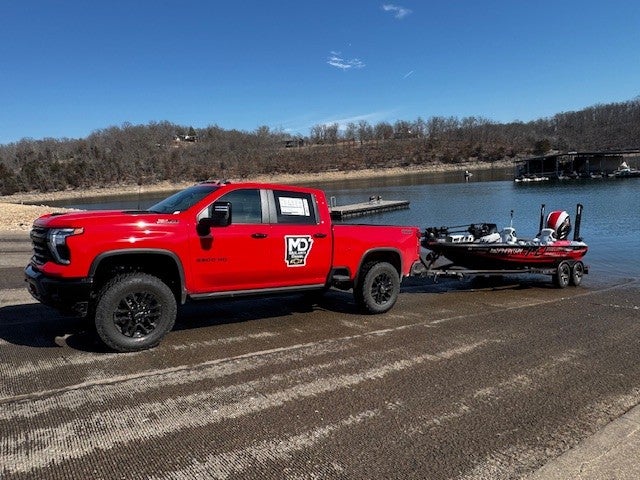 Silverado with trailer driving at sunset